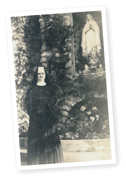Photo of Sister Annella Zervas, OSB, next to a statue of the Blessed Virgin Mary in Minnesota.
