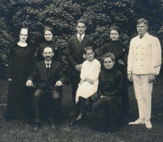 Sister Annella poses outside with her family for a family portrait.