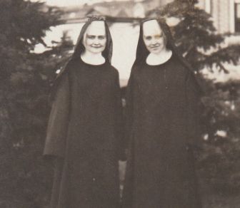 Sister Annella poses with another Benedictine sister in front of two trees.